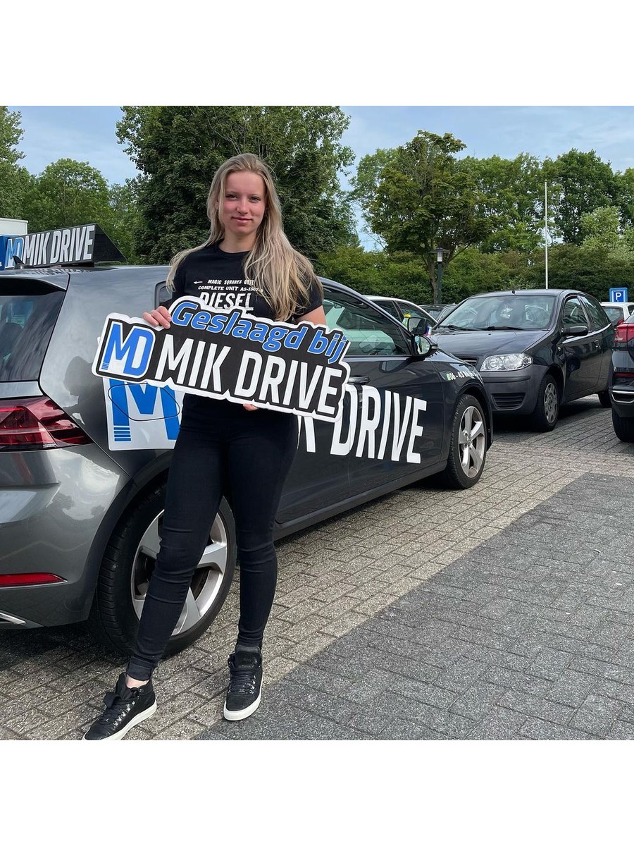 Geslaagde leerling bij de lesauto van MikDrive