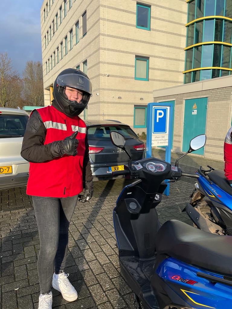 Geslaagde scooterleerling bij de lesscooter van MikDrive